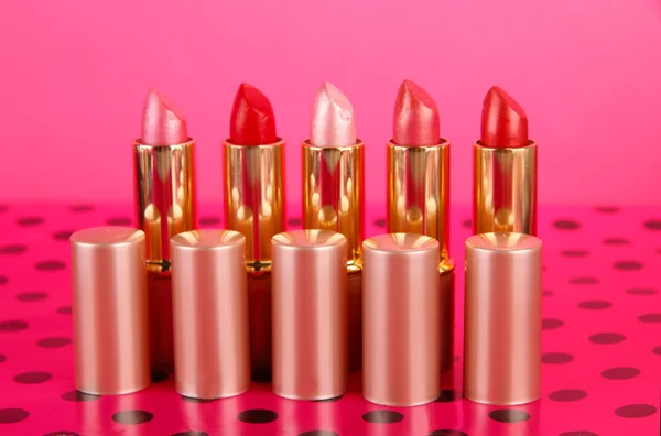 Lápiz labial sobre la mesa sobre fondo rosa —  Fotos de Stock