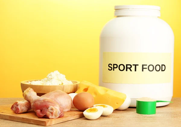 Jar of protein powder and food with protein, on yellow background — Stock Photo, Image