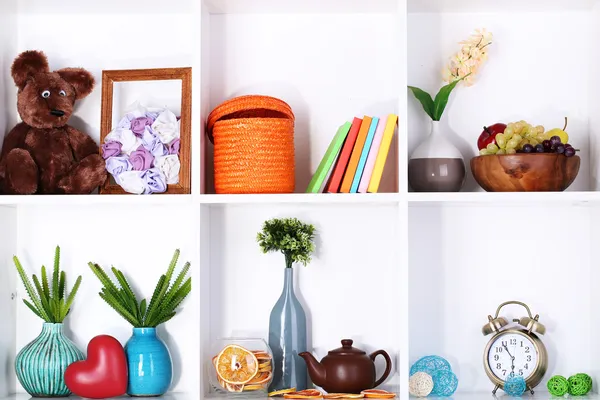 Prateleiras brancas bonitas com diferentes objetos relacionados com a casa — Fotografia de Stock