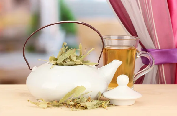 Getrocknete Kräuter in Teekanne auf Holztisch, auf hellem Hintergrund. Konzeptfoto von Kräutertee. — Stockfoto