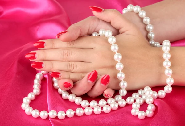 Female hands holding beads on color background Royalty Free Stock Images