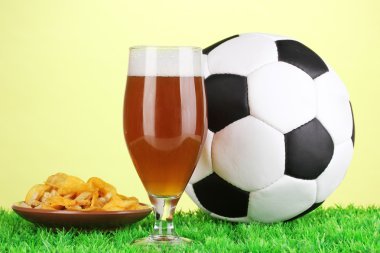 bardak bira ile çim yeşil zemin üzerine futbol topu