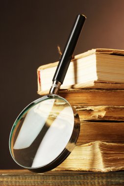 Büyüteç ve masa üzerine kitaplar