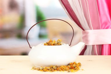 çaydanlık parlak zemin üzerine ahşap masa üzerinde kurumuş otlar. bitkisel çay kavramsal fotoğraf.