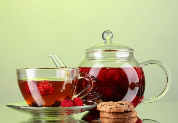 Té de frambuesa de fruta negra en tetera de vidrio y taza sobre fondo verde — Foto de Stock