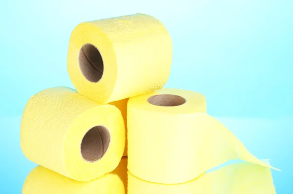 Yellow rolls of toilet paper on blue background — Stock Photo, Image