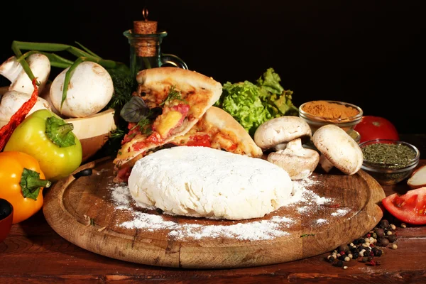 Lezzetli pizza hamuru, baharat ve sebzeler üzerinde kahverengi zemin ahşap tablo — Stok fotoğraf