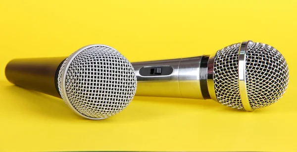 Microphones argent et noir sur fond jaune — Photo