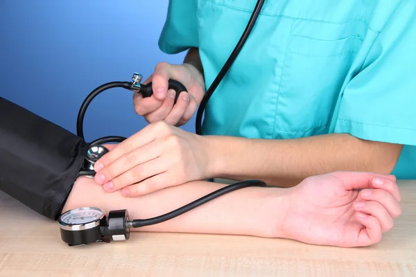 Medición de la presión arterial sobre fondo azul — Foto de Stock