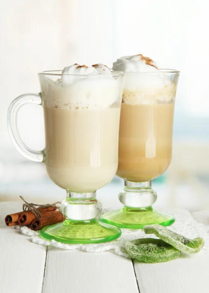 Voňavá káva latte v cups brýle s kořením, na dřevěný stůl — Stock fotografie