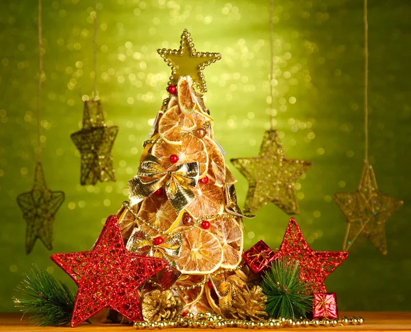 Hermoso árbol de Navidad de limones secos con decoración, sobre fondo verde brillante —  Fotos de Stock