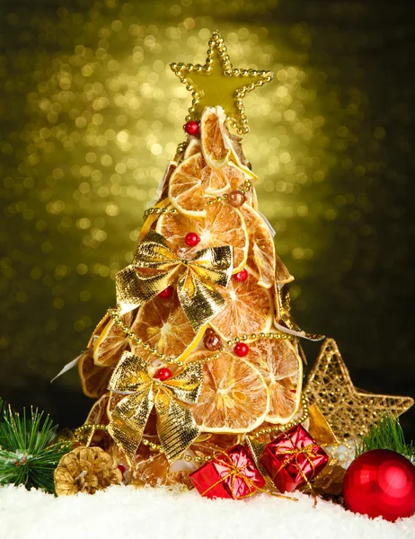 Beau sapin de Noël de citrons secs avec décor, sur fond de brillance — Photo