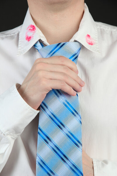Lipstick kiss on shirt collar of man, isolated on black