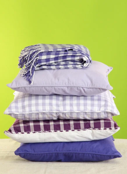 Hill colorful pillows and plaid on green background — Stock Photo, Image