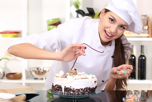 Wanita muda koki memasak kue di dapur — Stok Foto