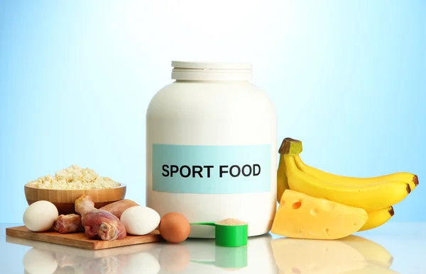Burk proteinpulver och mat med protein, på blå bakgrund — Stockfoto