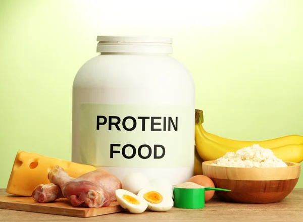 Jar of protein powder and food with protein, on green background — Stock Photo, Image