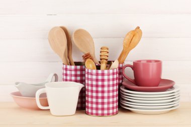 Cups, bowls nd other utensils in metal containers isolated on light background
