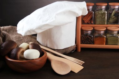 Şef'in şapkası ve kitchenwear tabloda gri arka plan üzerinde kompozisyonu