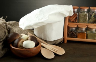 Şef'in şapkası ve kitchenwear tabloda gri arka plan üzerinde kompozisyonu