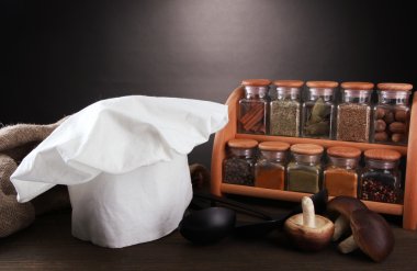 Şef'in şapkası ve kitchenwear tabloda gri arka plan üzerinde kompozisyonu