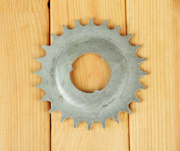 Metal cogwheel on wooden background — Stock Photo, Image