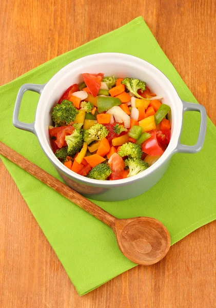 Vegetable stew in gray pot on color napkin on wooden background — Stock Photo, Image