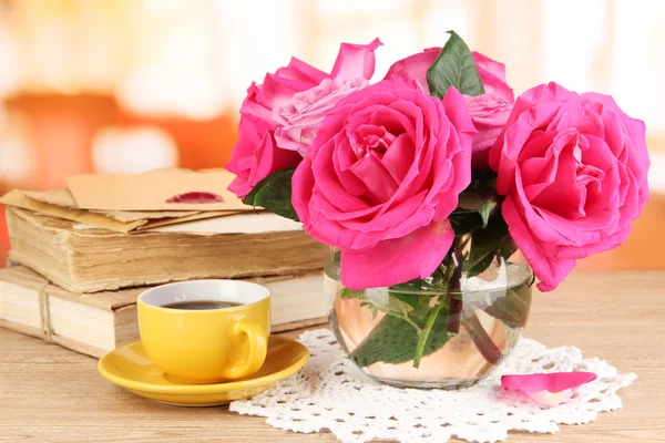 Mooie roze rozen in vaas op houten tafel op kamer achtergrond — Stockfoto