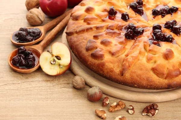 Вкусный домашний пирог с джемом и яблоками, на деревянном столе — стоковое фото