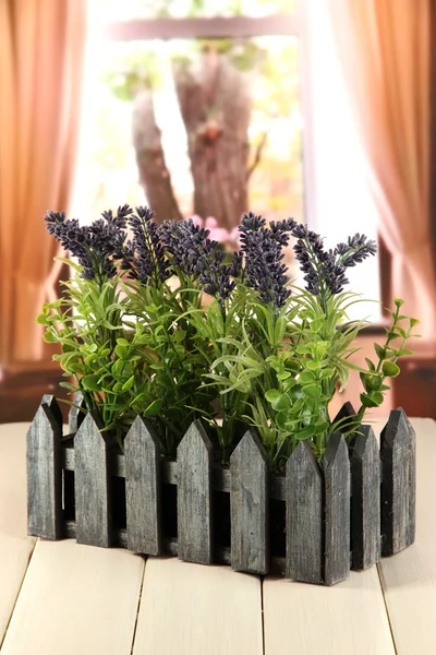 Decorative lavender in wooden box on wooden table on window background — Stock Photo, Image
