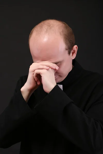 Young priest isolated on black — Stock Photo, Image