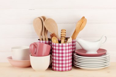 Cups, bowls nd other utensils in metal containers isolated on light background