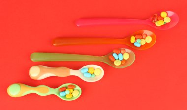 plastik kaşık kırmızı arka plan rengi hapları ile