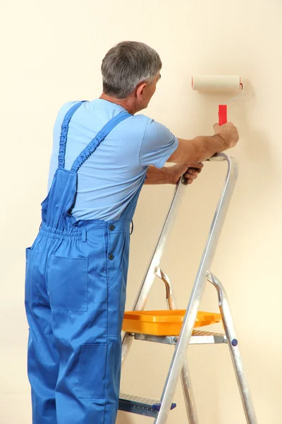 Pintor masculino pinta la pared en la habitación de cerca —  Fotos de Stock