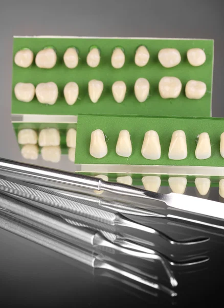Set med dental verktyg med protes på grå bakgrund — Stockfoto
