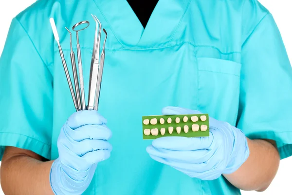 Zahnärzte Hände in blauen medizinischen Handschuhen mit zahnärztlichem Werkzeug und Prothese — Stockfoto