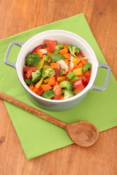 Zeleninový guláš v šedé hrnci na barevný ubrousek na dřevěné pozadí — Stock fotografie