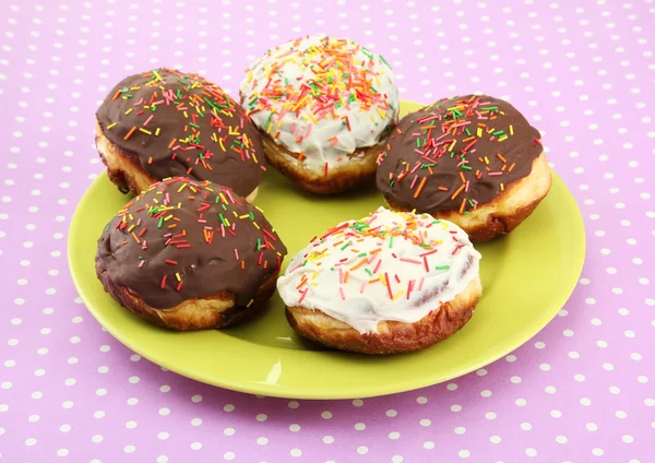 Leckere Donuts auf Farbteller auf Farbhintergrund — Stockfoto