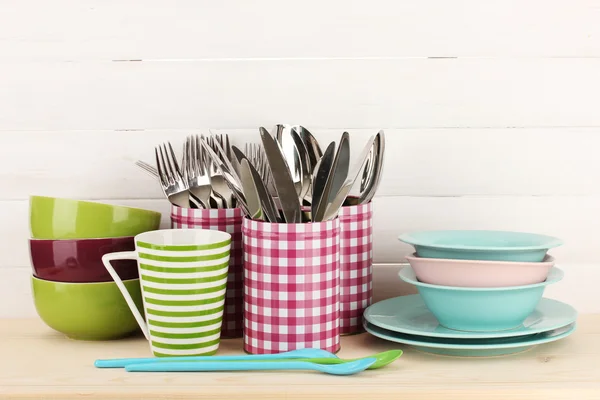 Cups, bowls nd other utensils in metal containers isolated on light background — Stok fotoğraf