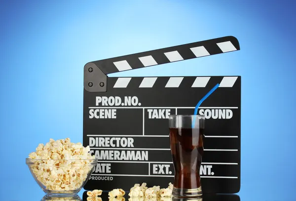 Bordo del film, cola e popcorn su sfondo blu — Foto Stock