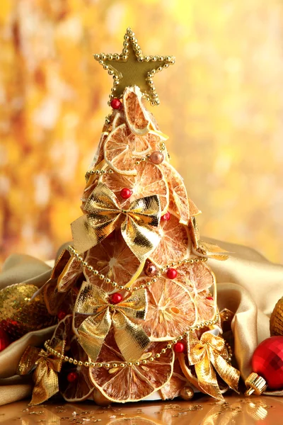 Hermoso árbol de Navidad de limones secos con decoración, sobre fondo amarillo — Foto de Stock