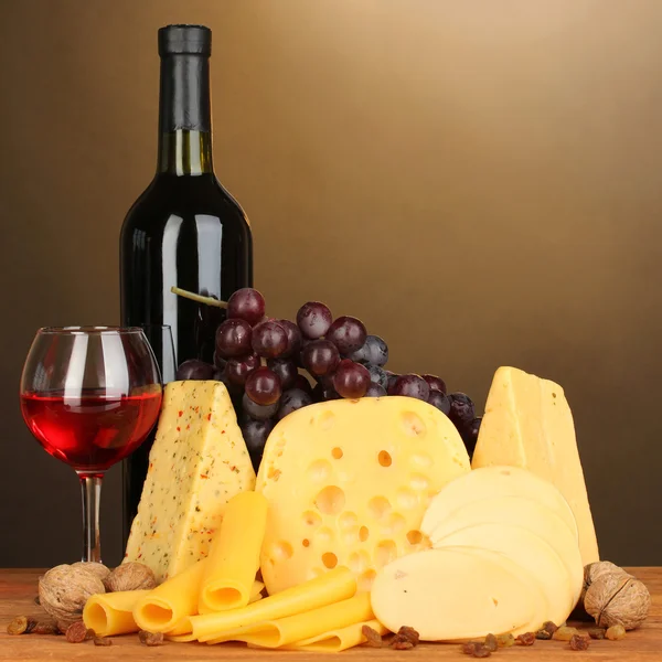 Varios tipos de queso sobre mesa de madera sobre fondo marrón —  Fotos de Stock