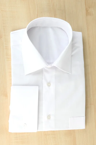 Nueva camisa de hombre blanco sobre fondo de madera — Foto de Stock