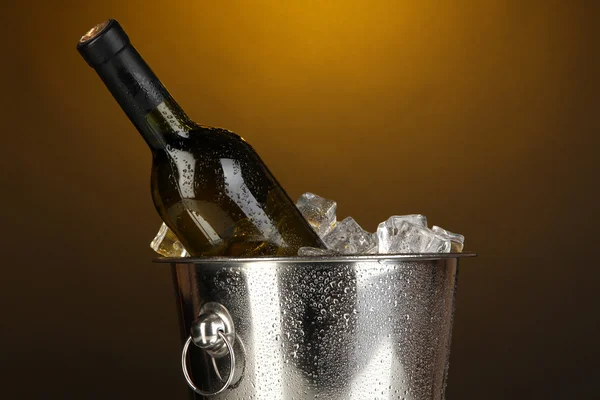 Láhev vína v ledové vědro na darck žluté pozadí — Stock fotografie
