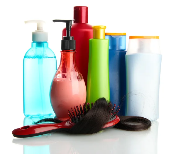 Pinceau peigne avec des cheveux et des bouteilles cosmétiques, isolé sur blanc — Photo