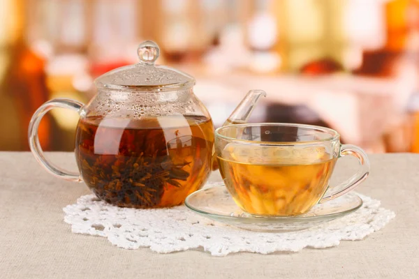 Exotic green tea with flowers in glass teapot on bright background — Stock Photo, Image