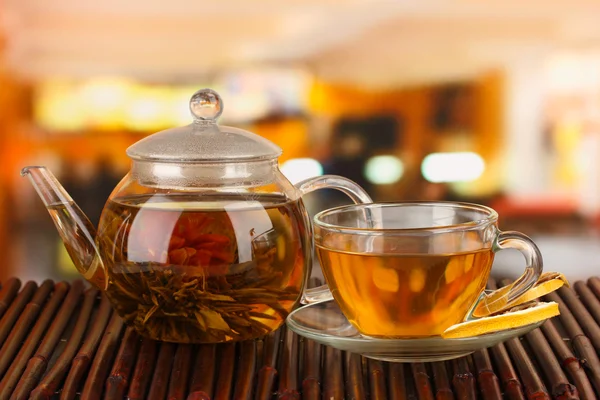Exotické zelený čaj s květy ve skleněné konvici na světlé pozadí — Stock fotografie