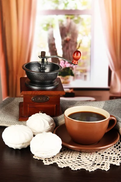 Taza de café con bufanda y molino de café en la mesa en la habitación —  Fotos de Stock