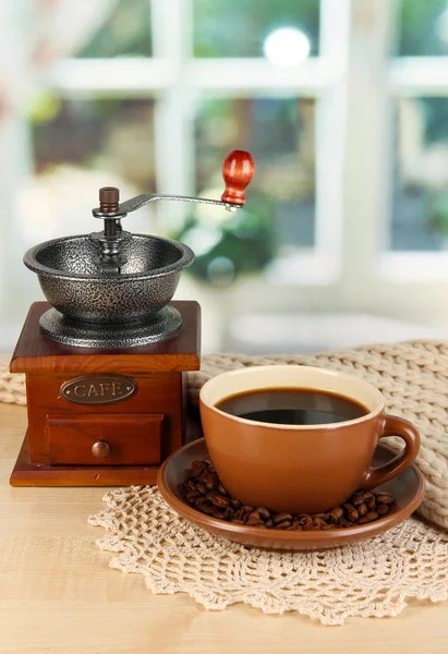 Φλιτζάνι καφέ με κασκόλ και μύλος καφέ στο τραπέζι στην αίθουσα — Φωτογραφία Αρχείου