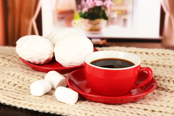 Tasse de café avec écharpe sur la table dans la chambre — Photo